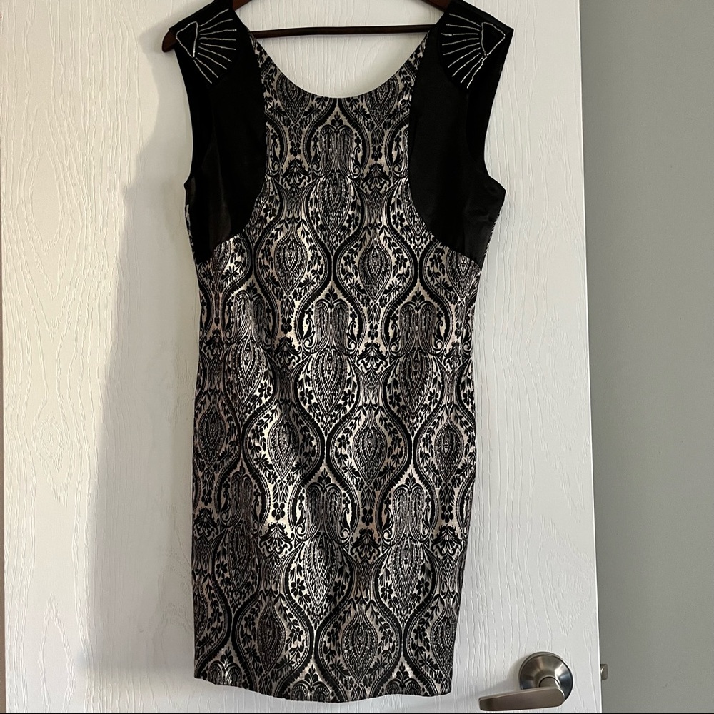 Fitted black and silver dress with beaded shoulder treatment.
